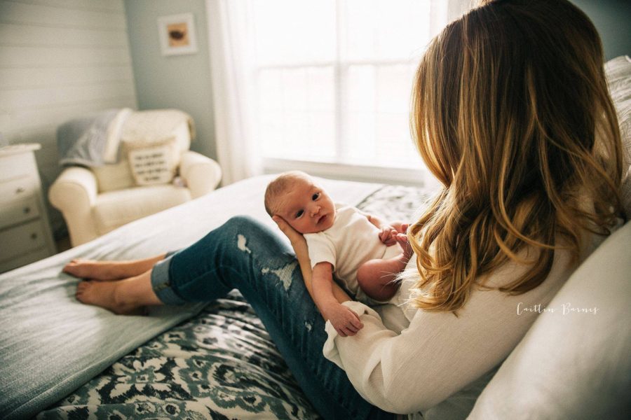 mom holding baby on bed, daily fan favorite