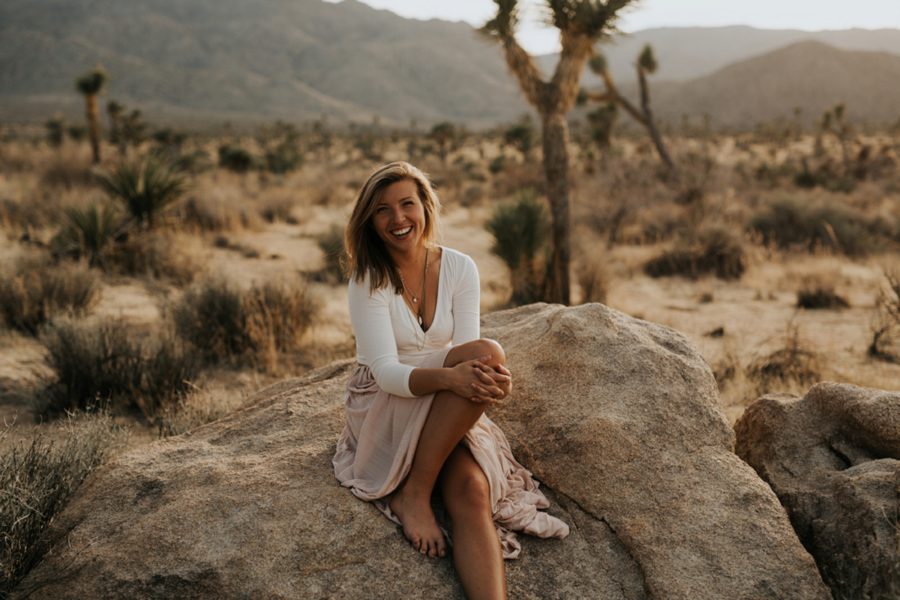 Portrait of woman sitting on rock, Portraits in desert, Moody Couples Session at Joshua Tree