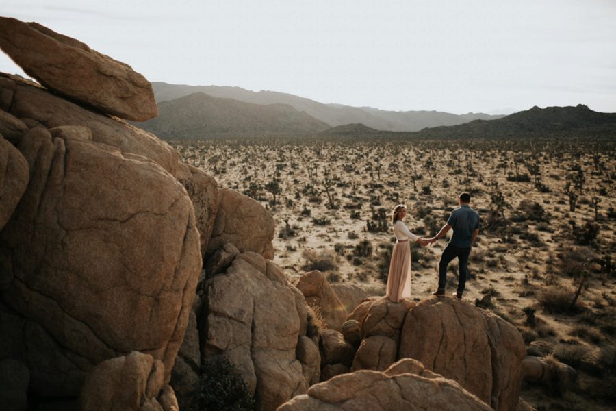 man and woman holding hands on rock, unique couple posing, Moody Couples Session at Joshua Tree