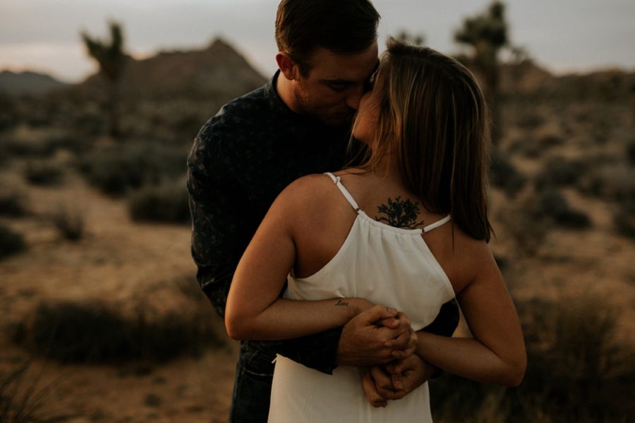 tasteful tattoos, man and woman almost kissing, hands entangled, Moody Couples Session at Joshua Tree