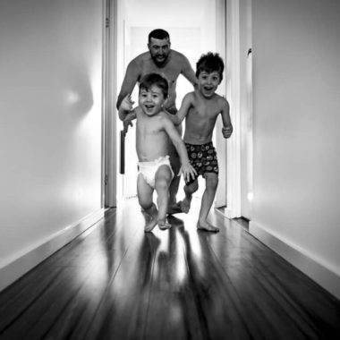 Dad playing chase with kids, boys running down hallway, Daily Fan Favorite