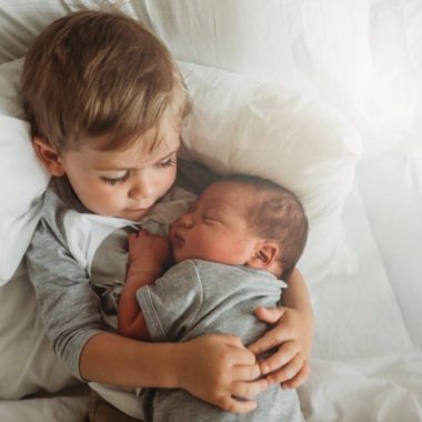 Sibling holding newborn, overhead shot of brother holding new baby, Andrea Martin Photography Daily Fan Favorite