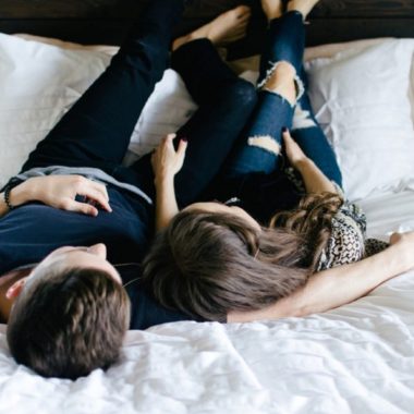 Couple lying on bed together with their feet on the headboard, Nashville Lifestyle Couples Session