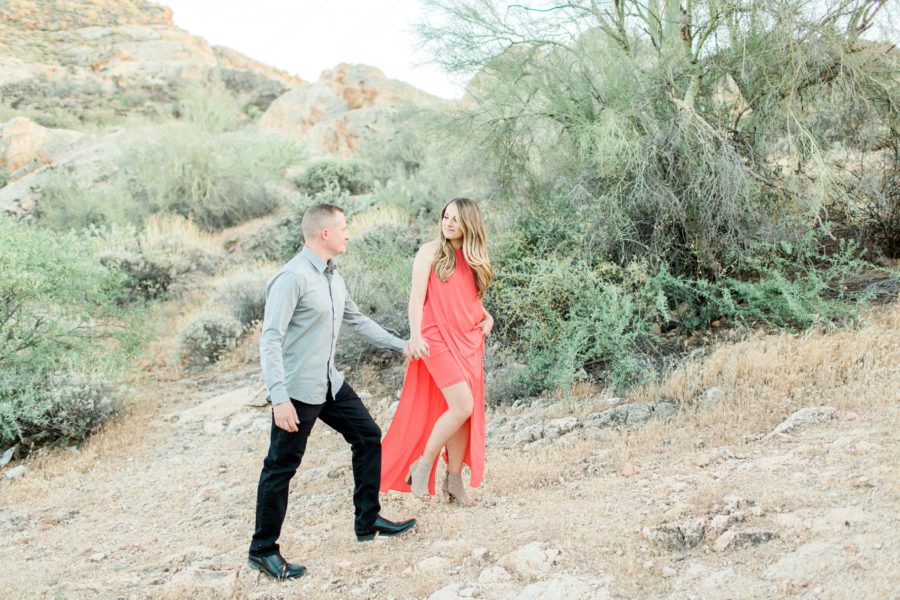 Couple holding hands and smiling at each other, Arizona desert, Canyon Lake Engagement Pictures in Arizona