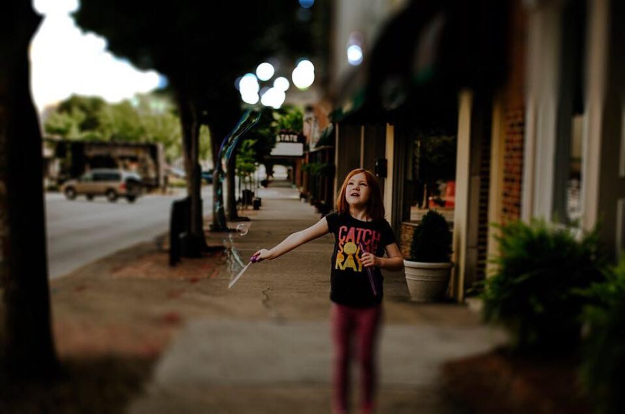 Girl standing on sidewalk with bubble wand, Daily Fan Favorites on Beyond the Wanderlust