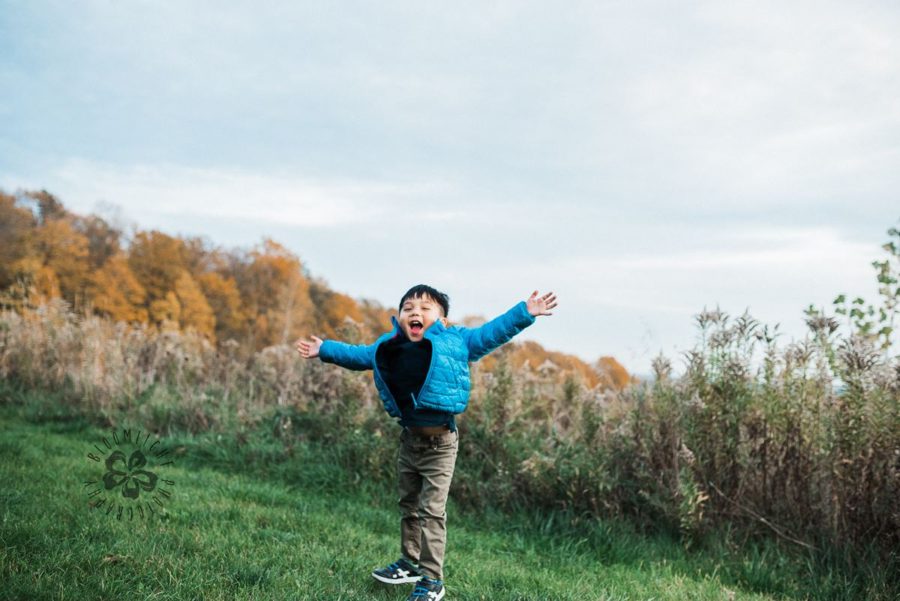 Joyful child with arms out in grass, Beyond the Wanderlust daily fan favorite