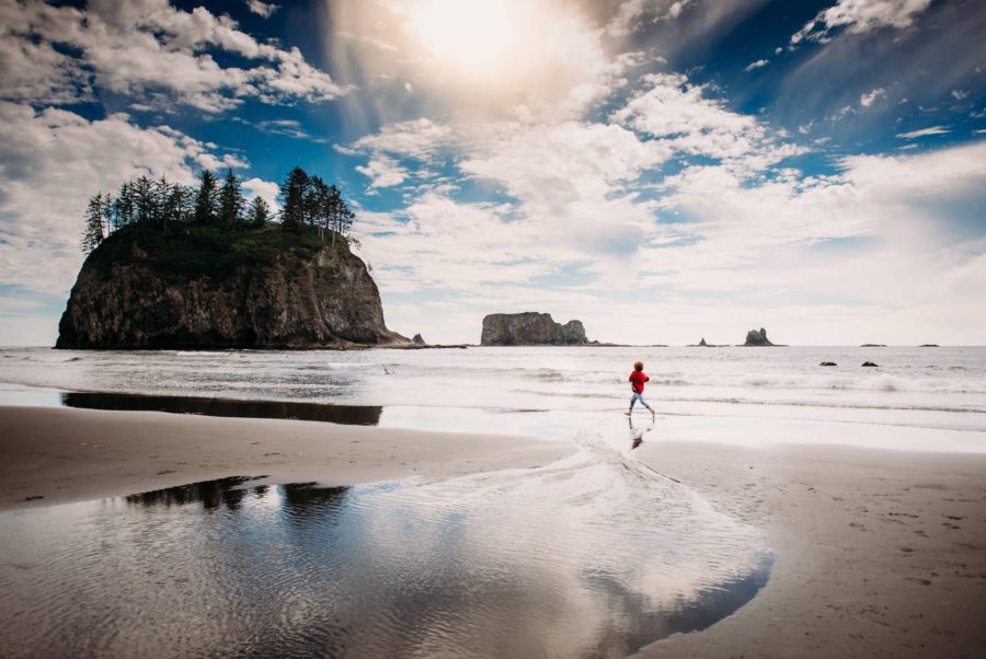 child running on coast with big rocks, Beyond the Wanderlust daily fan favorite