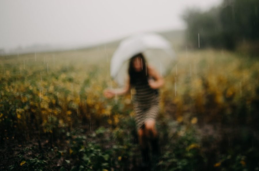 Picture of rain falling with girl and umbrella in background, Beyond the Wanderlust Daily Fan Favorite