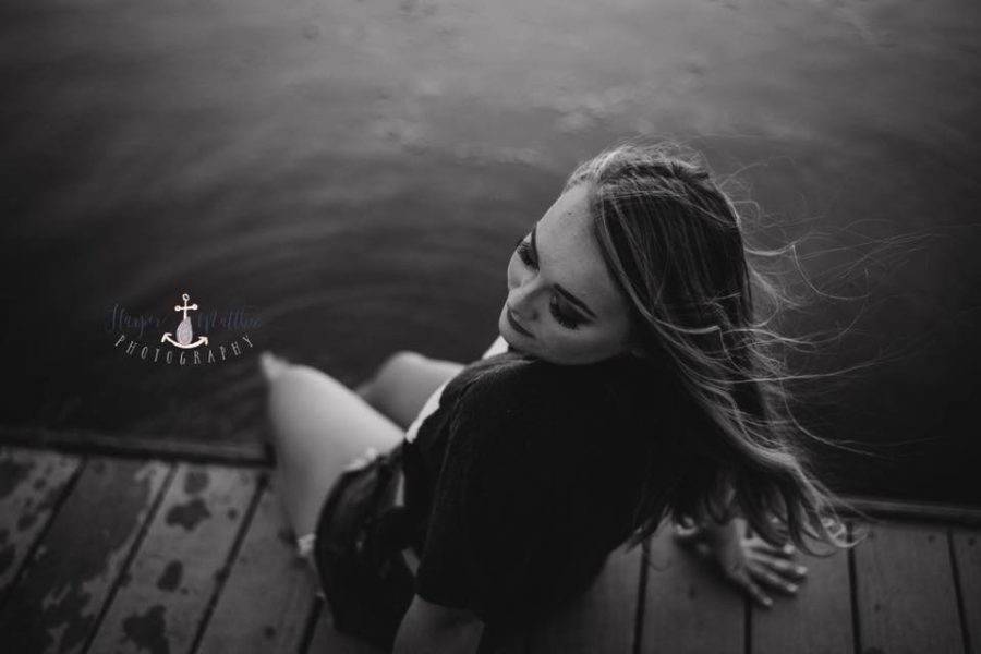 Overhead shot of girl sitting on dock with feet in water, Beyond the Wanderlust Daily Fan Favorite