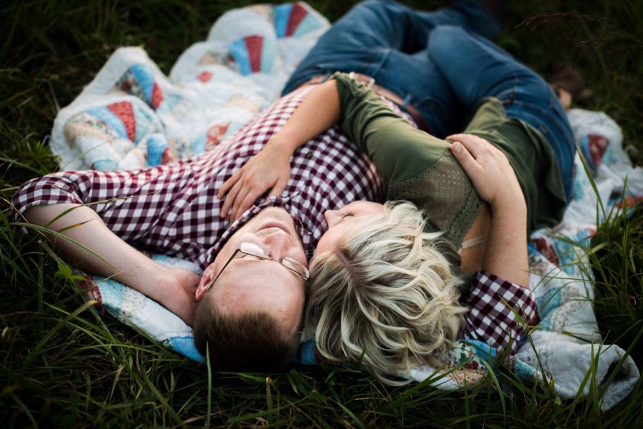 Couple lying on quilt embracing with hand on chest, Beyond the Wanderlust Daily Fan Favorite 