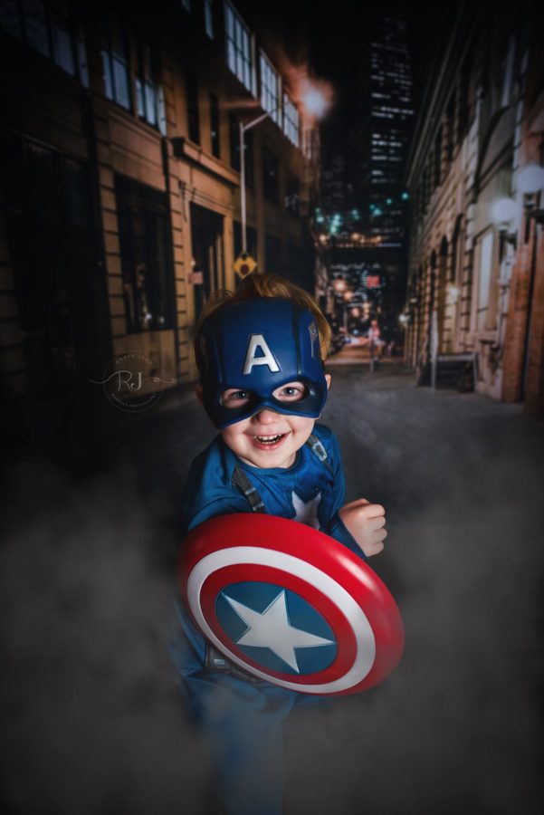 Boy wearing super hero costume city lights in background, Beyond the Wanderlust Daily Fan Favorites 