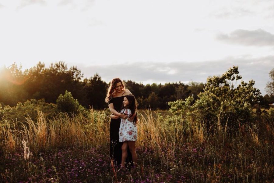 Woman and girl embracing in field, Beyond the Wanderlust Daily Fan Favorites 