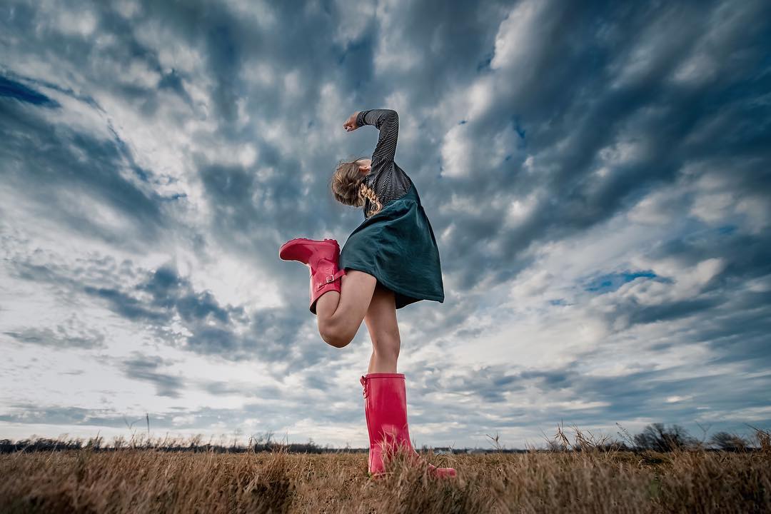 spring pictures, stormy skies, girl dancing for skyline pictures, lifestyle kid pictures