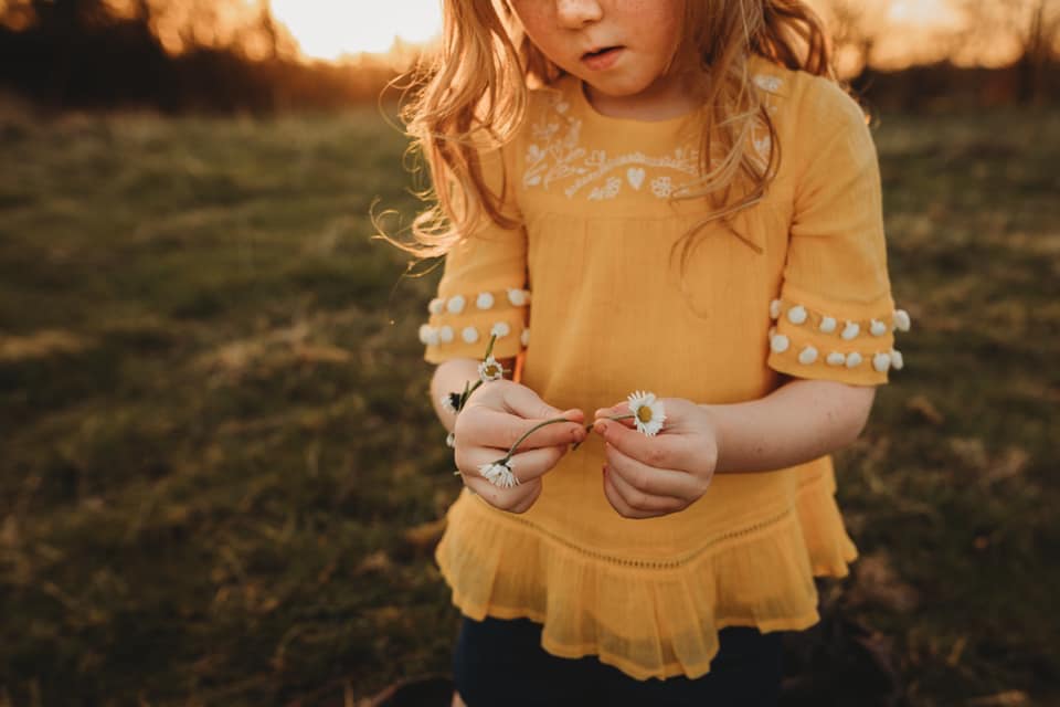 spring pictures of kids, girl holding daisies, what to wear for kids in family pictures, golden hour