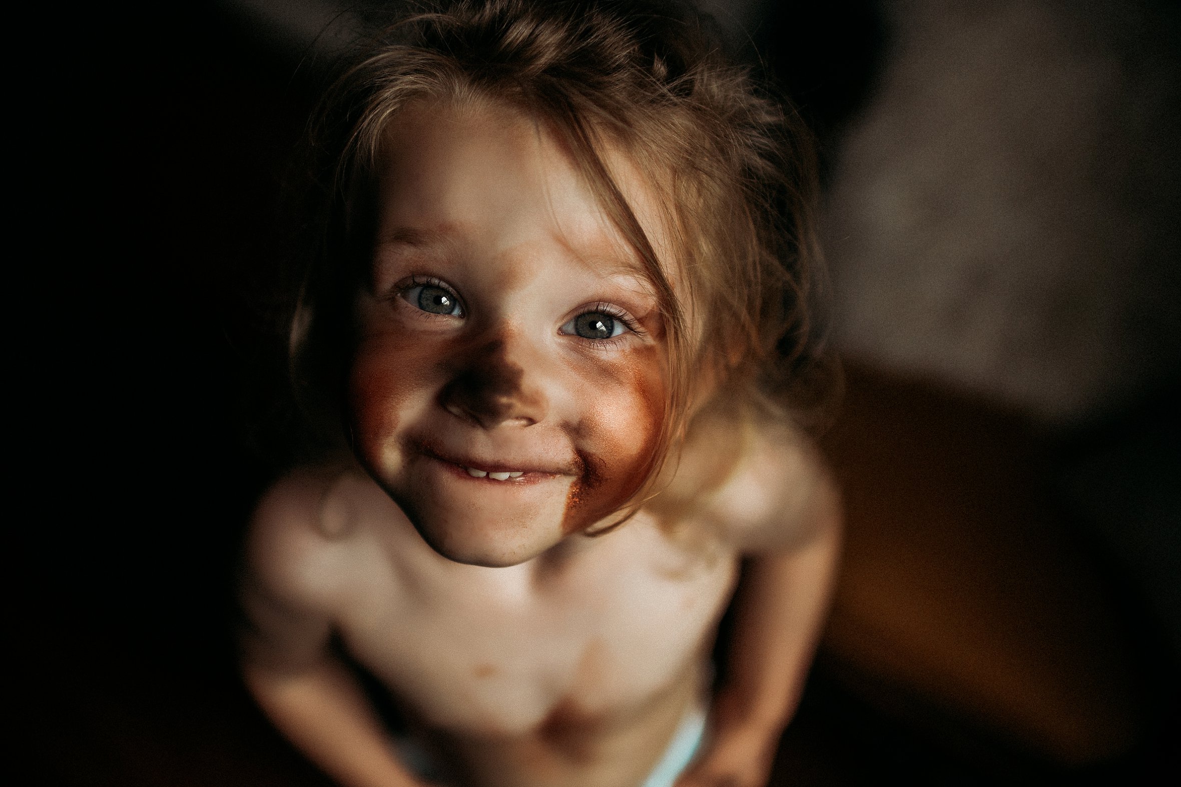 little girl smiling covered in makeup - lifestyle kid - indoor light