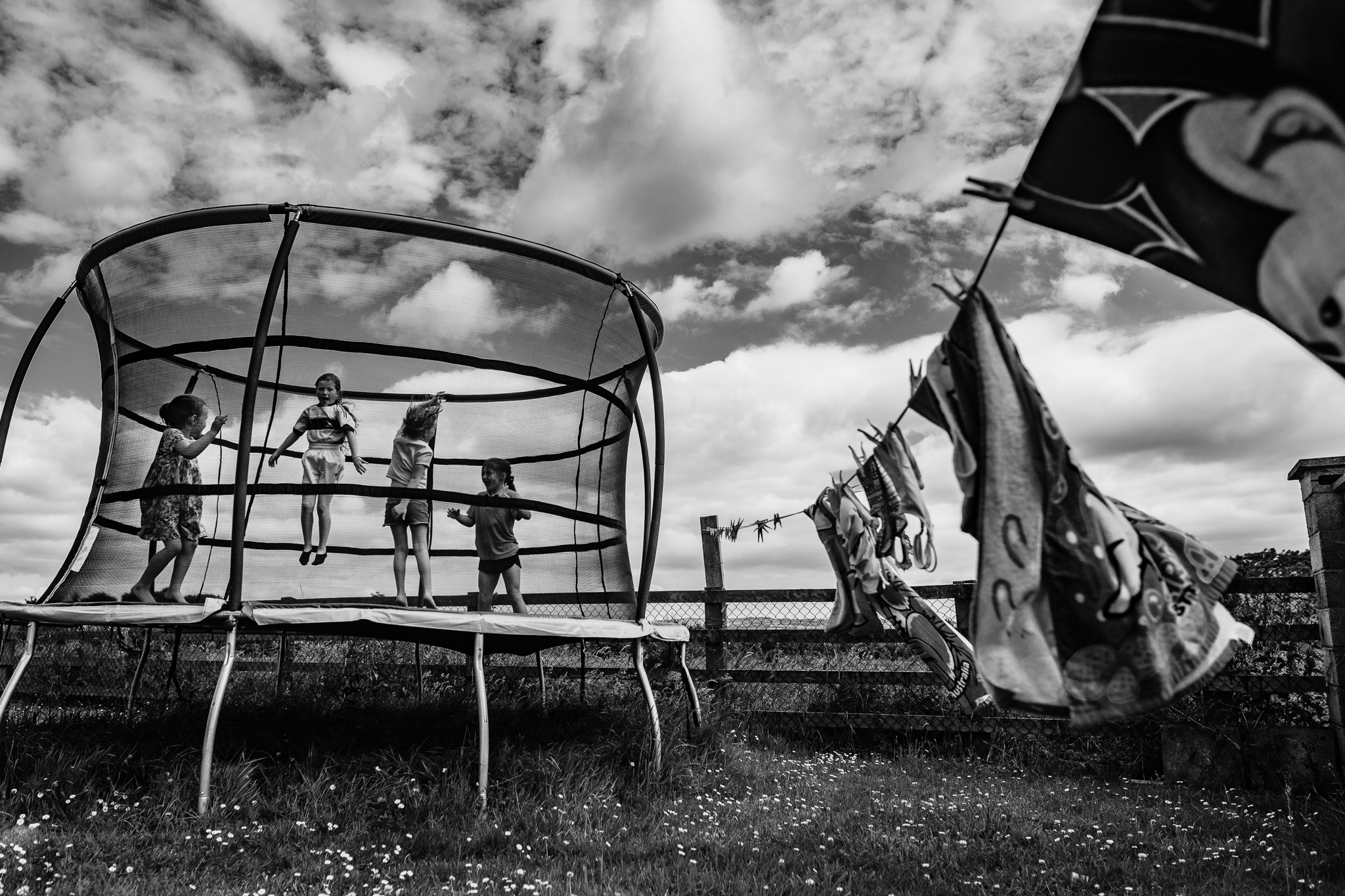 trampoline, laundry, country living, documentary kids, black and white portrait, blue sky with big clouds, lifestyle family pictures, siblings